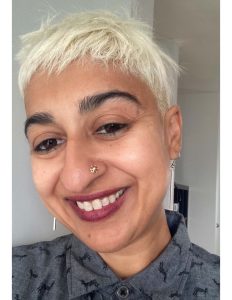 Headshot of Ronica Mukerjee wearing earrings and a nose piercing.