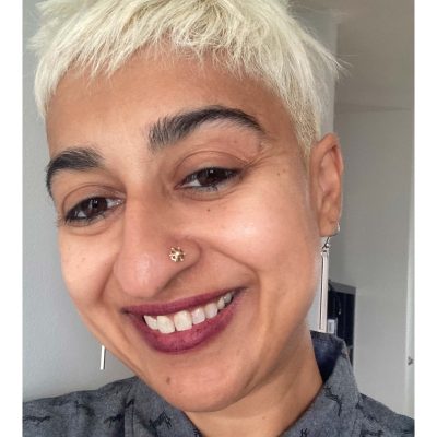 Headshot of Ronica Mukerjee wearing earrings and a nose piercing.