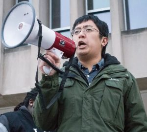 Leland speaking into a megaphone outside