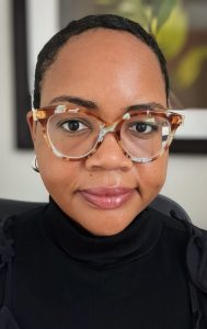 Headshot of Bethany wearing glasses and a black shirt