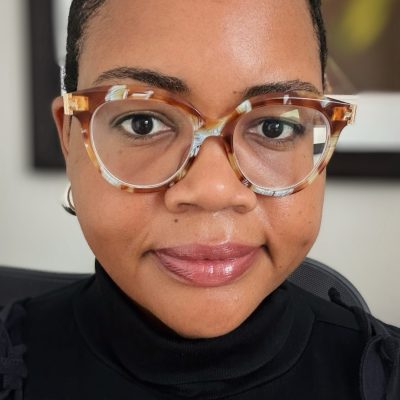 Headshot of Bethany wearing glasses and a black shirt